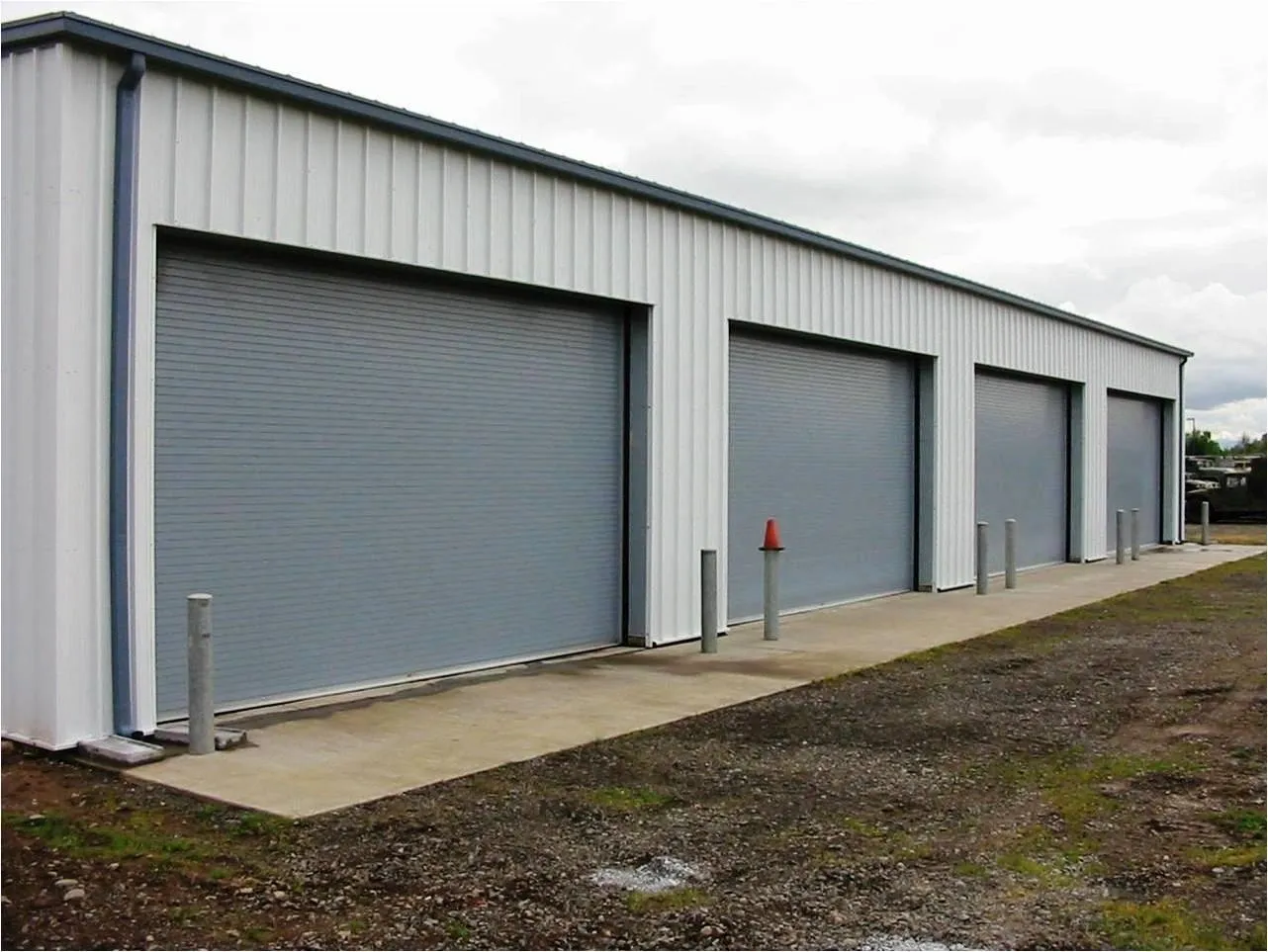 A building with three garage doors on the side of it.